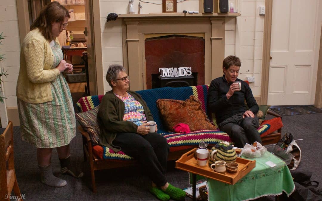 people sittitng at coffee table with fireplace in background