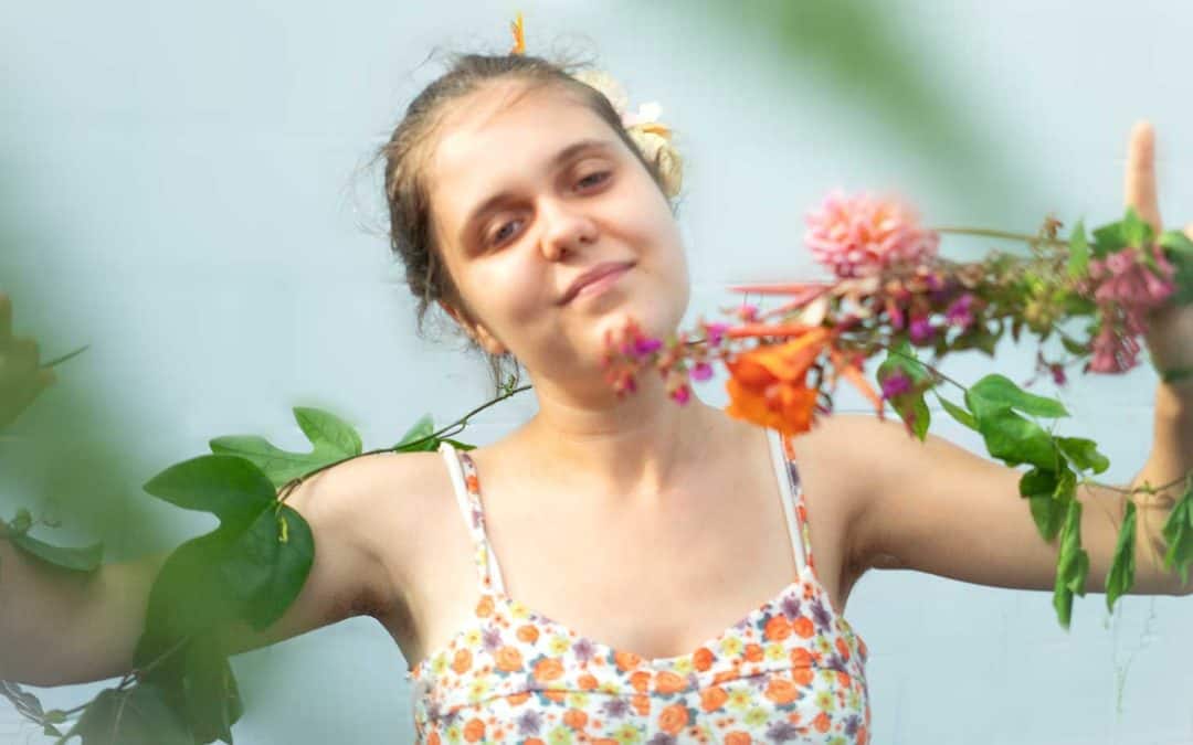 young woman in floral dress with floral items on her arms