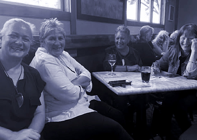 happy people sitting around table, blueish black and white image