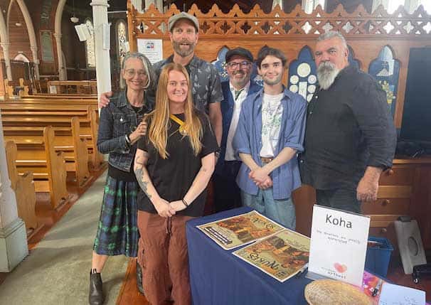 2 women and 4 men stading at a counter in a chuech