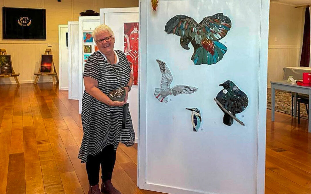 older woman in dress standing next to huge painting in a gallery